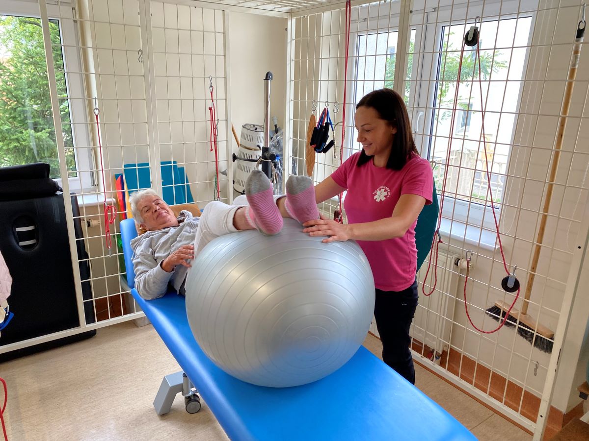 Na zdjęciu widać podopieczną Gdyńskiego Ośrodka Wsparcia ćwiczącą pod okiem rehabilitantki.