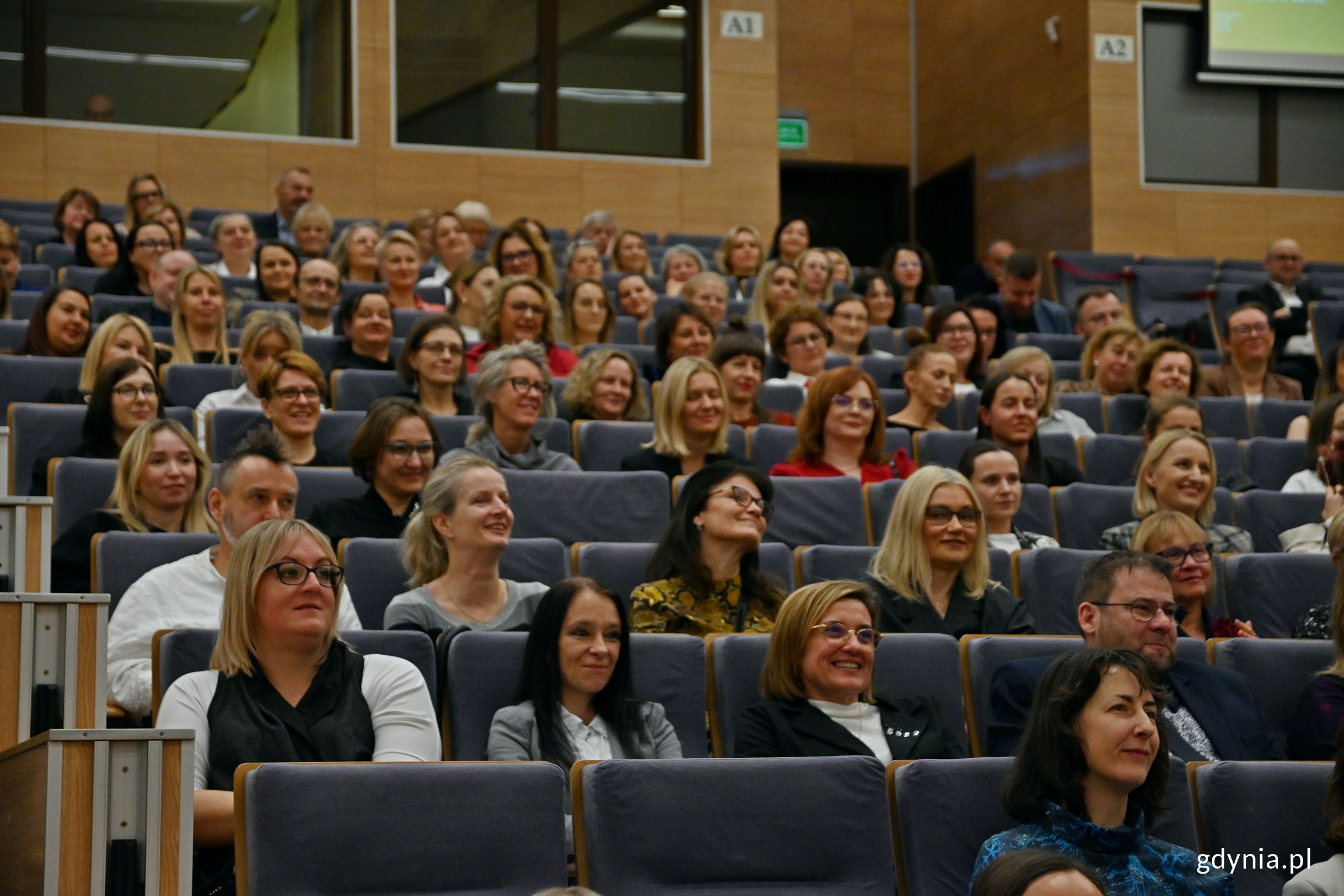 Duża grupa ludzi w r&oacute;żnym wieku na widowni