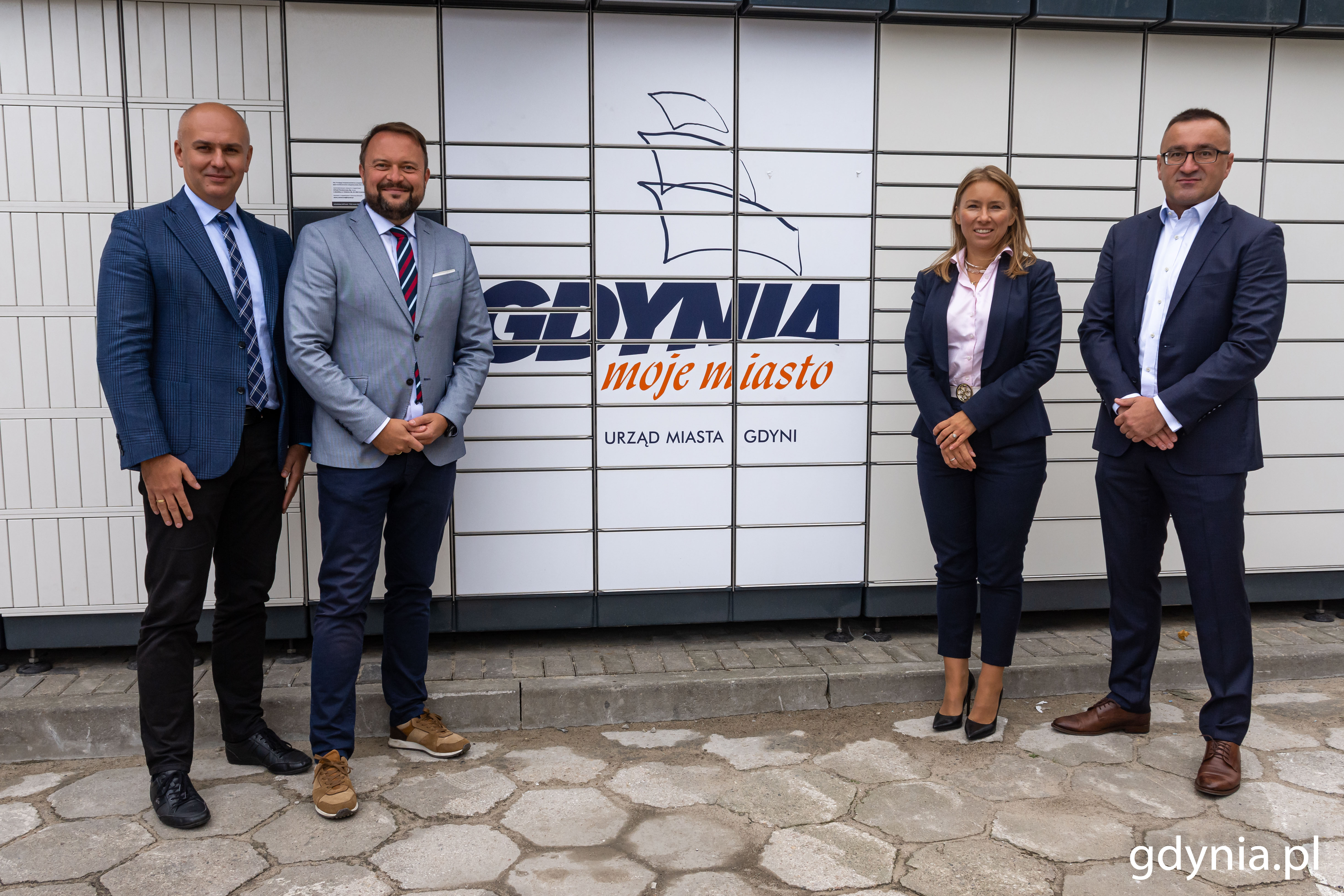 Od lewej: Rafał Klajnert - dyrektor Urzędu Miasta Gdyni, Marek Łucyk - wiceprezydent Gdyni ds. rozwoju, Izabela Karolczyk-Szafrańska - dyrektor marketingu InPost oraz Wojciech Kądziołka - rzecznik prasowy InPost na tle paczkomatu // fot. Magdalena Czernek
