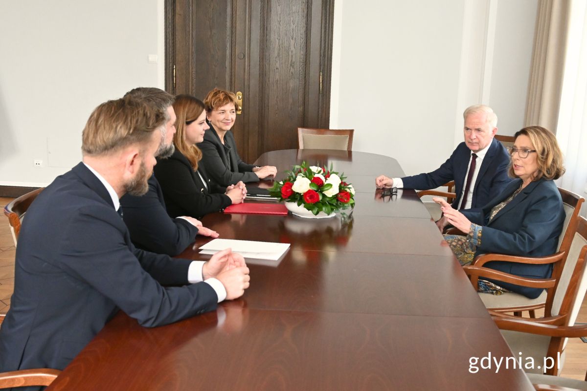 Dyrektor Muzeum Miasta Gdyni Karin Moder, przewodniczący Rady Miasta Gdyni Tadeusz Szemiot, prezydent Gdyni Aleksandra Kosiorek, marszałek Senatu MaDyrektor Muzeum Miasta Gdyni Karin Moder, prezydent Gdyni Aleksandra Kosiorek i przewodniczący Rady Miasta Gdyni Tadeusz Szemiot siedzący przy stole konferencyjnym z senatorami Ryszardem Świlskim i Sławomirem Rybickim oraz marszałek Senatu Małgorzatą Kidawą-Błońską