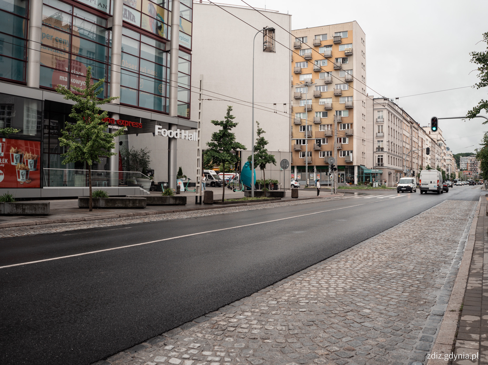 nowa nawierzchnia asfaltowa oraz z kostki, w tle budynki iruch uliczny