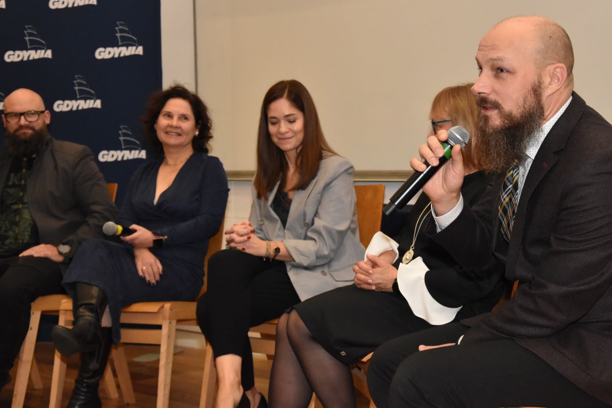 Na zdjęciu grupa ludzi uczestniczących w panelu dyskusyjnym z okazji święta pracownik&oacute;w pomocy społecznej.