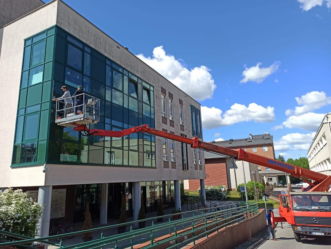 Montaż specjalnych marker&oacute;w, kt&oacute;re mają zapobiegać kolizjom ptak&oacute;w z szybami, w oknach budynku nr 5 Szpitala Morskiego im. PCK w Gdyni przy pomocy wysięgnika // fot. materiały Szpitali Pomorskich