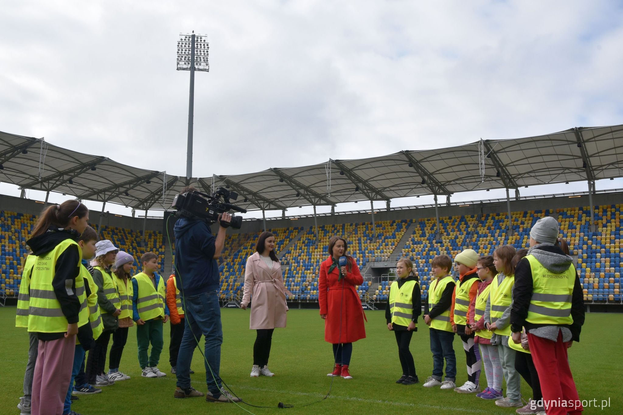 wejście na żywo w telewizji prosto ze stadionu miejskiego - dzieci obsługa stojący na murawie