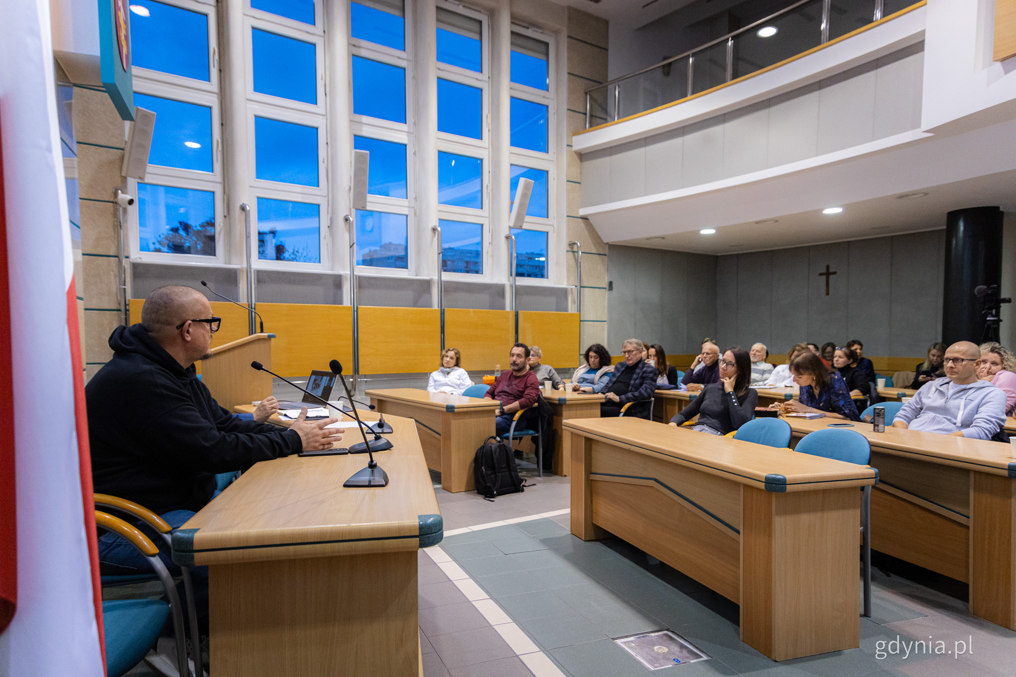 Sala obrad Rady Miasta Gdyni, Jacek Piątek siedzi przy stole i przemawia do grupy radnych dzielnicowych