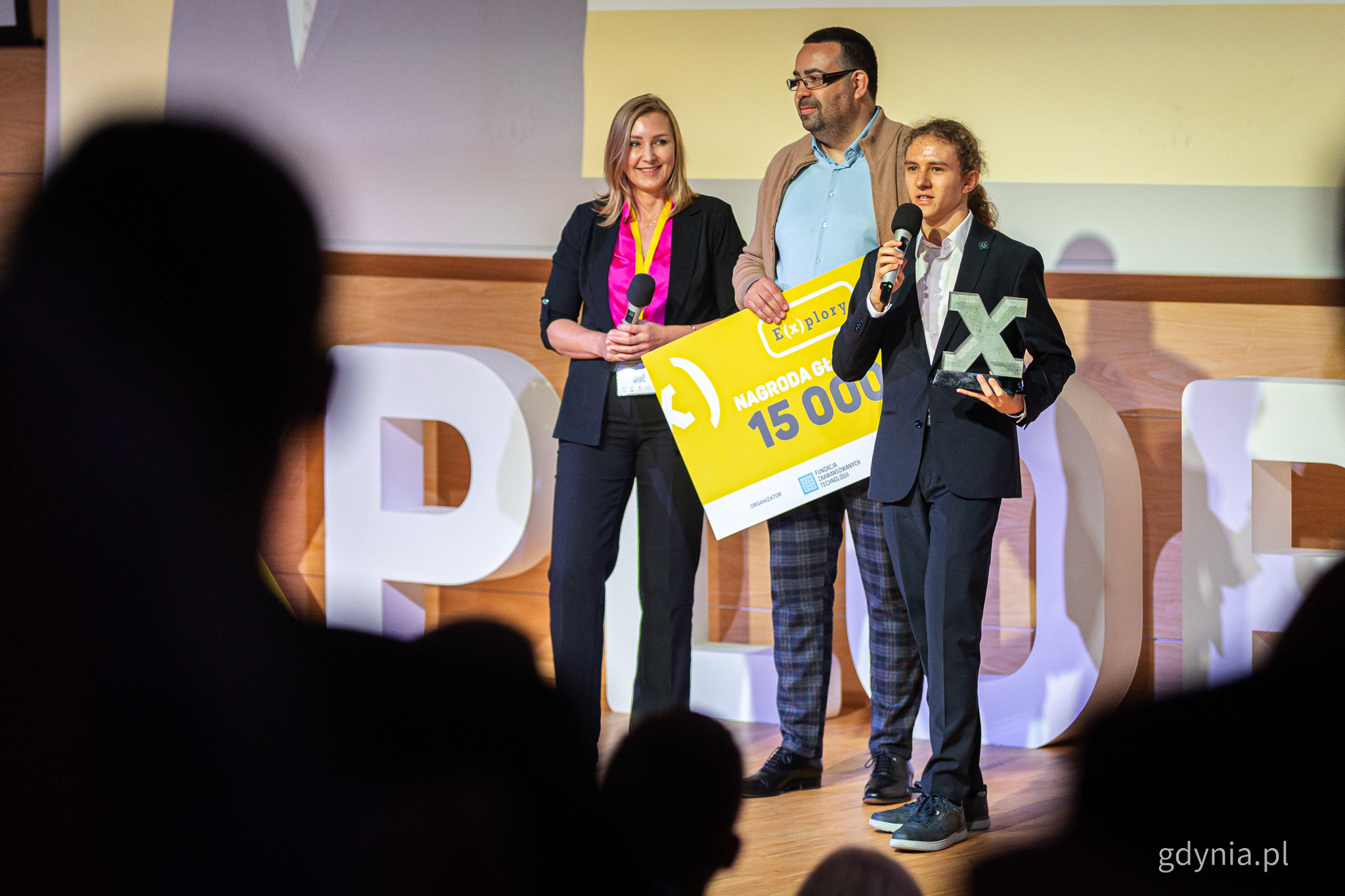 Scena PPNT, trzy osoby, nastolatek trzymający nagrodę - Emil Pająk - przemawia przez mikrofon