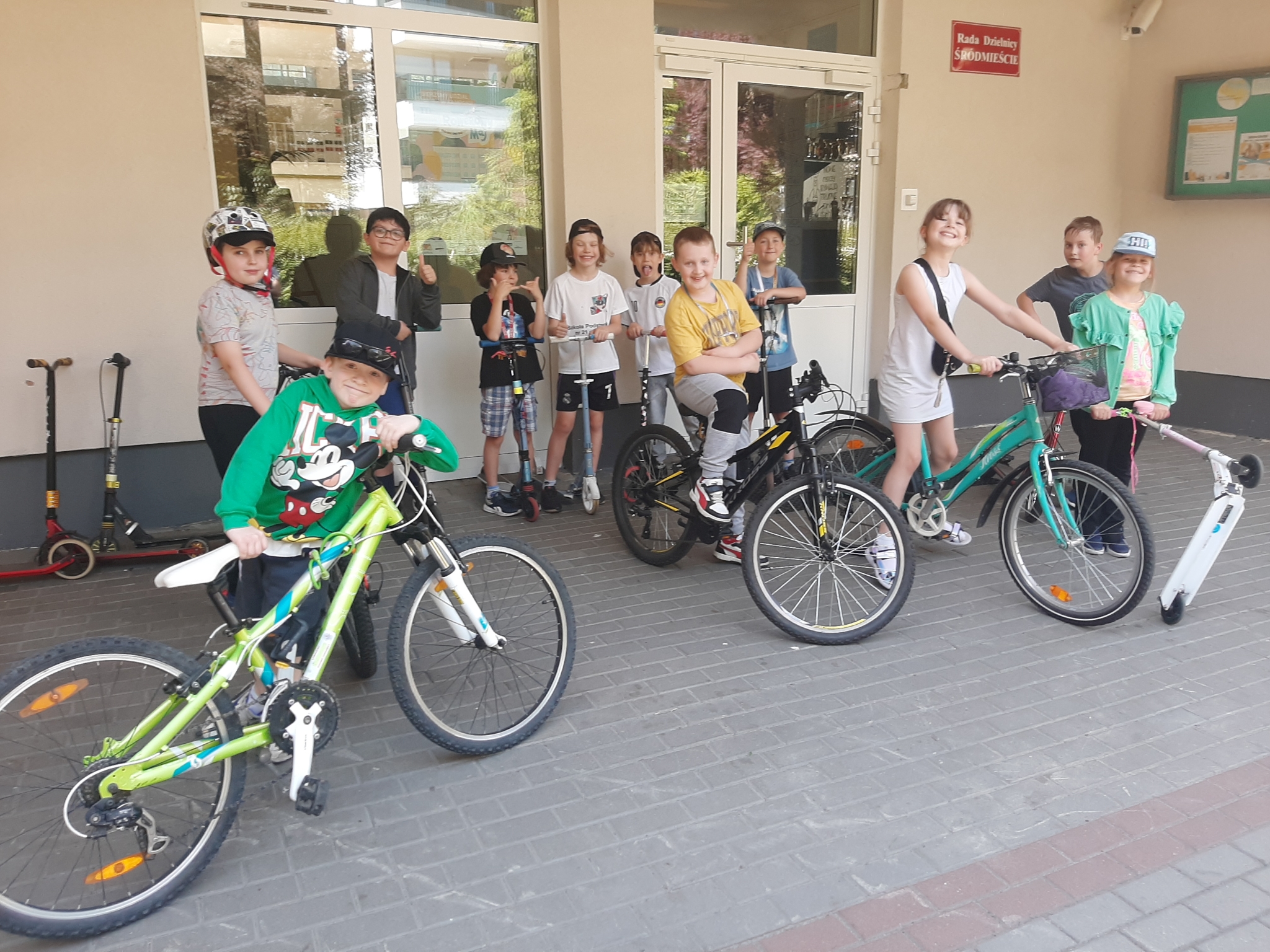 uczniowie z jednośladami przed szkołą