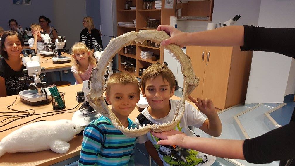 Dw&oacute;jka dzieci trzymająca eksponat