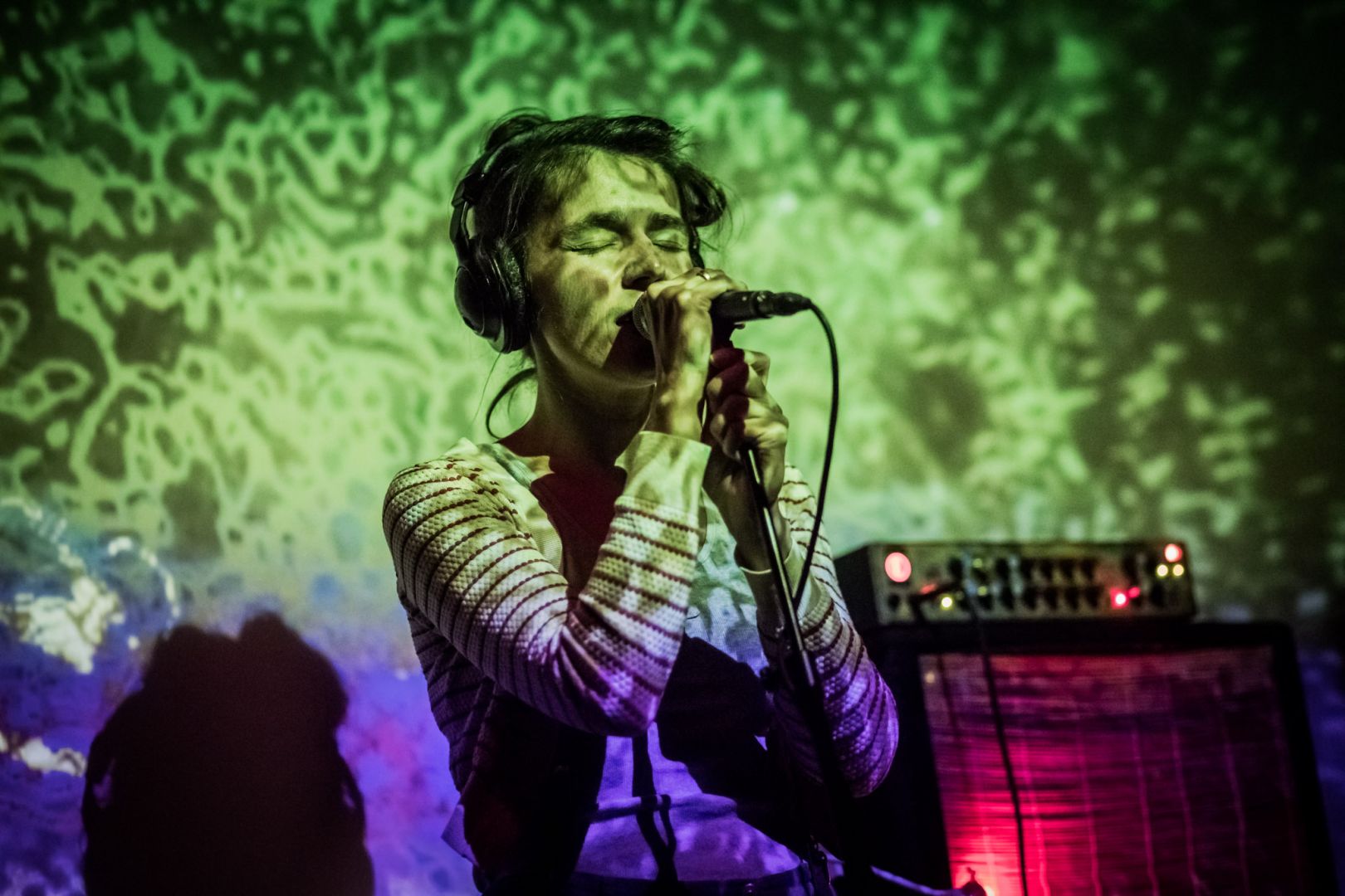 Wokalistka śpiewa podczas koncertu zespołu drewnofromlas. Na jej twarz padają kolorowe światła // fot. Wojtek Rojek