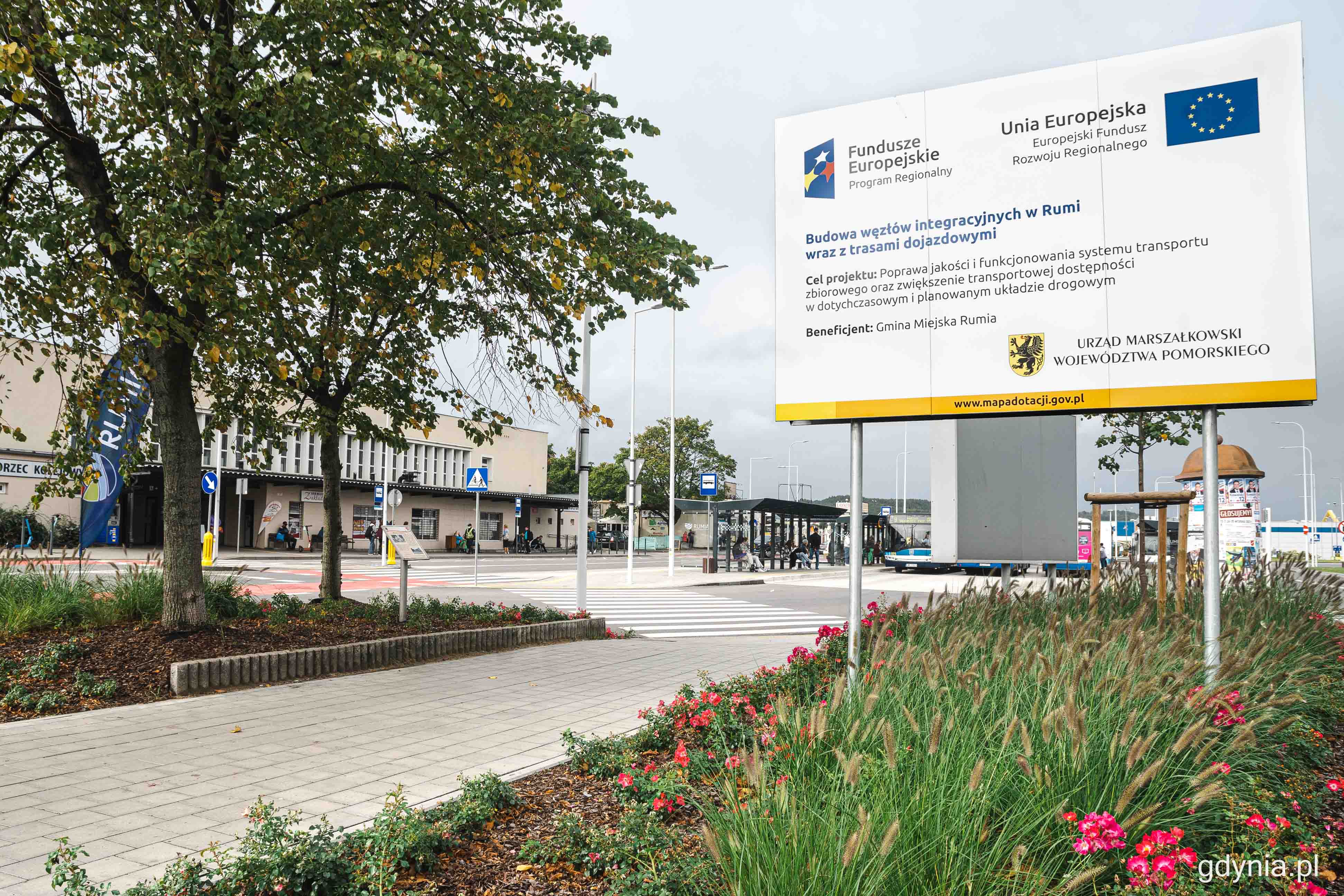 Dworzec PKP Rumia, tablica unijna, budynek dworca, ulica, przejścia dla pieszych, wiaty przystankowe, autobusy przy przystankach
