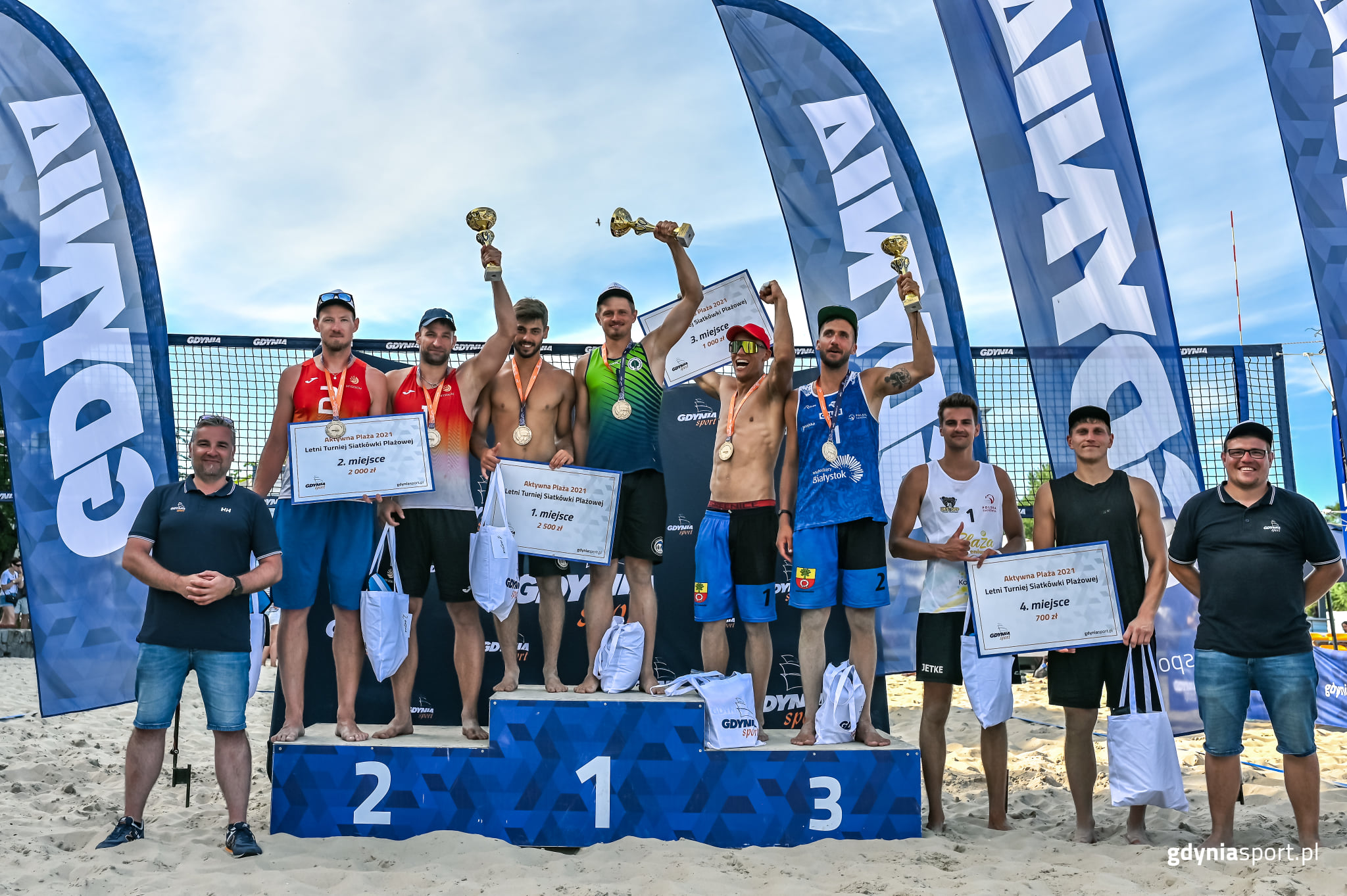 Na zdjęciu widzimy najlepsze cztery pary turnieju mężczyzn, trzy z nich na podium z medalami i pucharami.