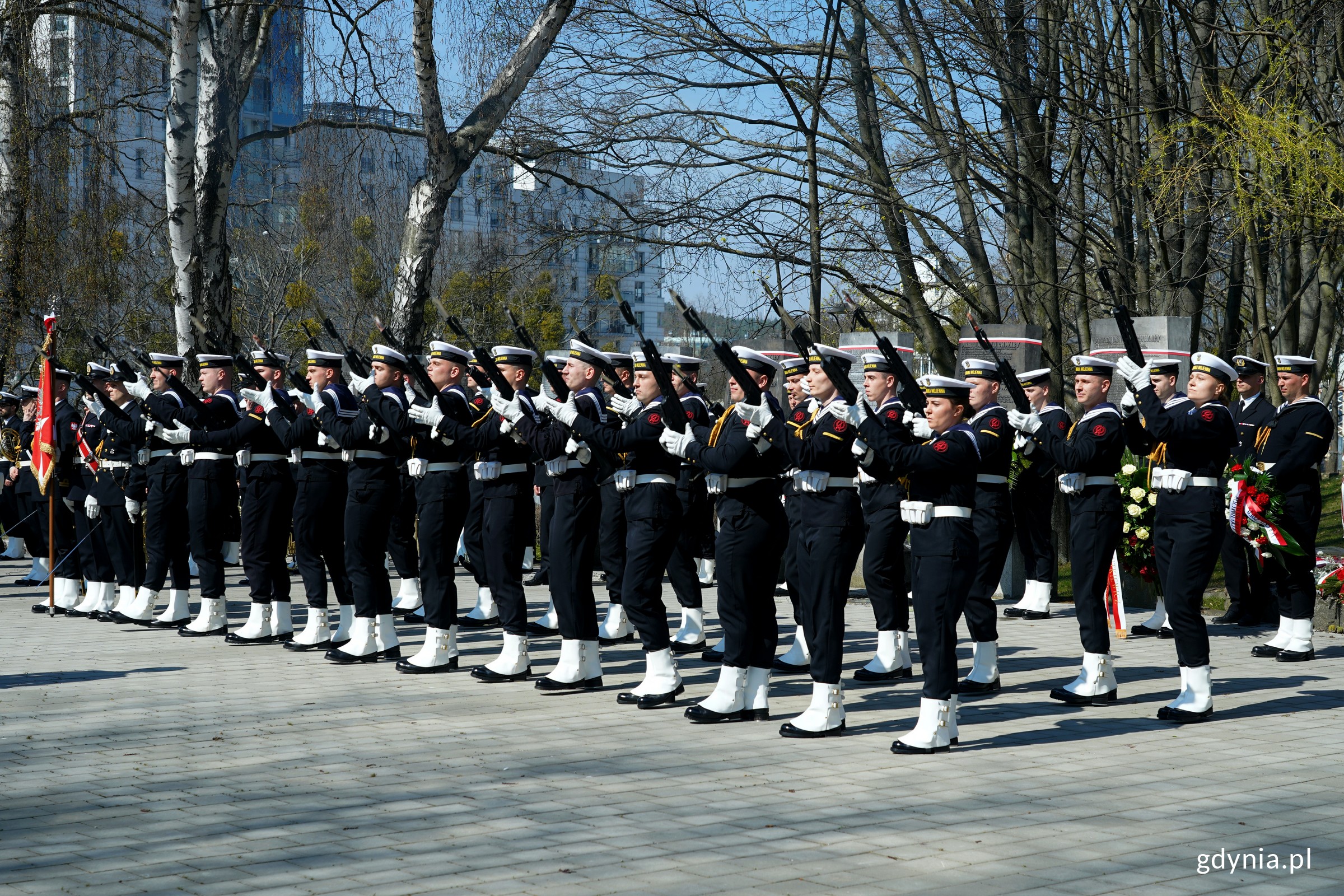 Żołnierze Marynarki Wojennej w galowych mundurach oddający salwę honorową podczas uroczystości z okazji Dnia Pamięci Ofiar Zbrodni Katyńskiej 