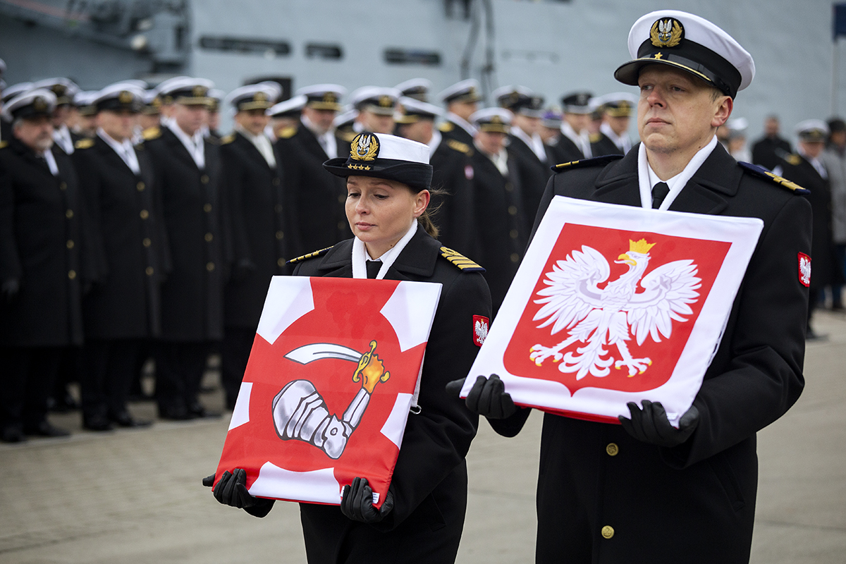 Dow&oacute;dca okrętu kmdr. ppor. Michał Narłowski prezentuje otrzymaną banderę wojenną, a zastępca dow&oacute;dcy okrętu kpt. mar. Patrycja Jurdzińska prezentuje otrzymany proporzec Marynarki Wojennej. Fot. Przemysław Kozłowski