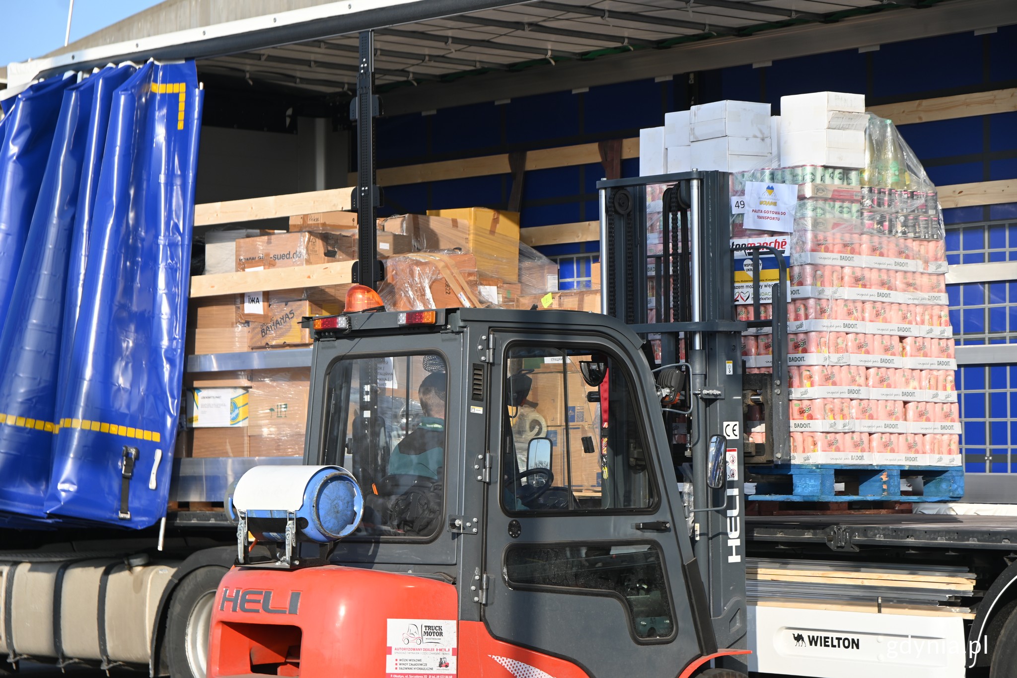 Załadunek tira, kt&oacute;ry zawiezie pomoc humanitarną na Ukrainę. W&oacute;zek widłowy kładzie paletę z produktami // fot. Magdalena Czernek
