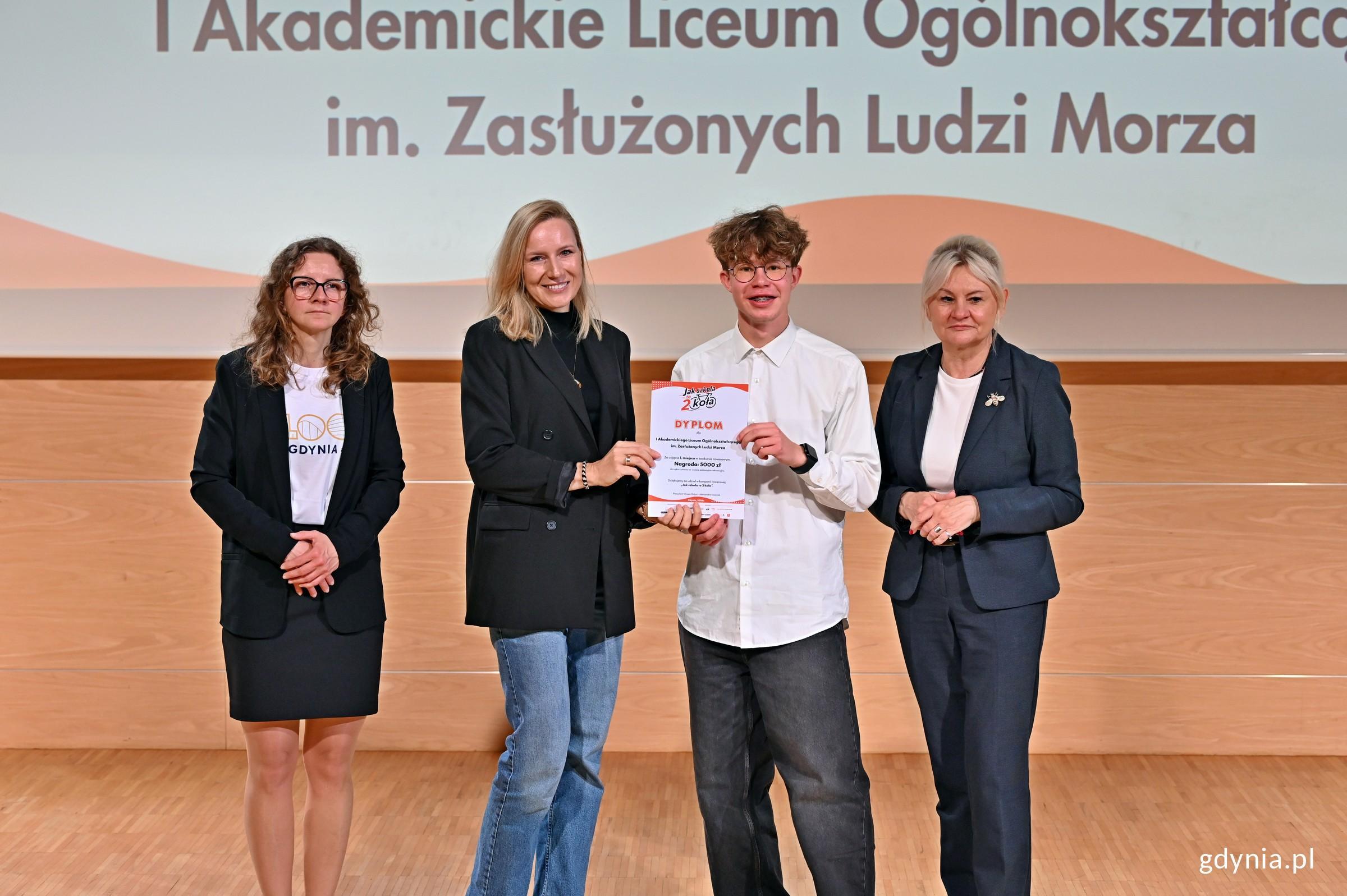 Przedstawiciele I Akademickiego Liceum Og&oacute;lnokształcącego w Gdyni Dezyderia Pawlak i Łukasz Głodowski z dyplomem i nagrodą dla szkoły za największą aktywność w kampanii &bdquo;Jak szkoła to dwa koła&rdquo;. Na zdjęciu z Iwoną Tanewska &ndash; naczelniczką Wydziału Edukacji Urzędu Miasta Gdyni i Dominiką Godlewską&nbsp;&ndash; koordynatorką kampanii &bdquo;Jak szkoła to dwa koła&rdquo; z ramienia Referatu Zarządzania Ruchem i Mobilnością Urzędu Miasta Gdyni