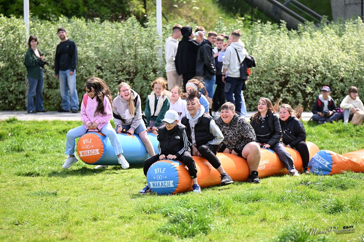 Grupa uśmiechniętych dzieci i młodzieży na gumowych rurach podczas zabawy