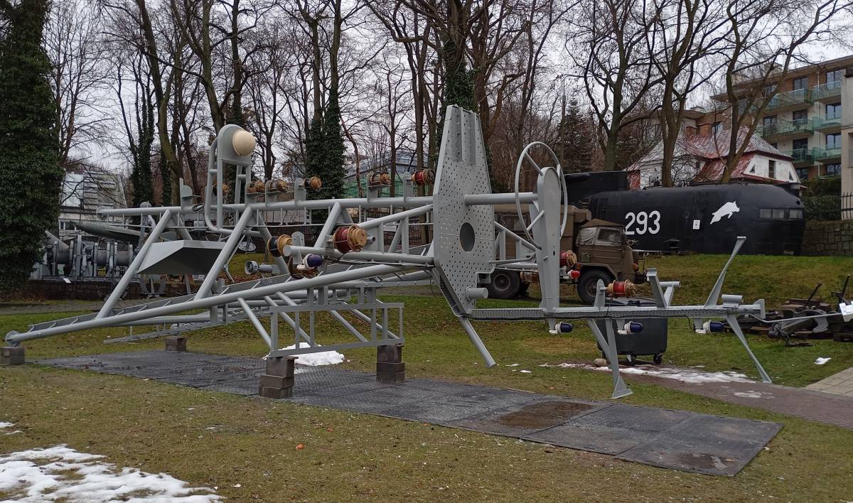 Szary maszt okrętu leżący na ciemnej macie na trawniku