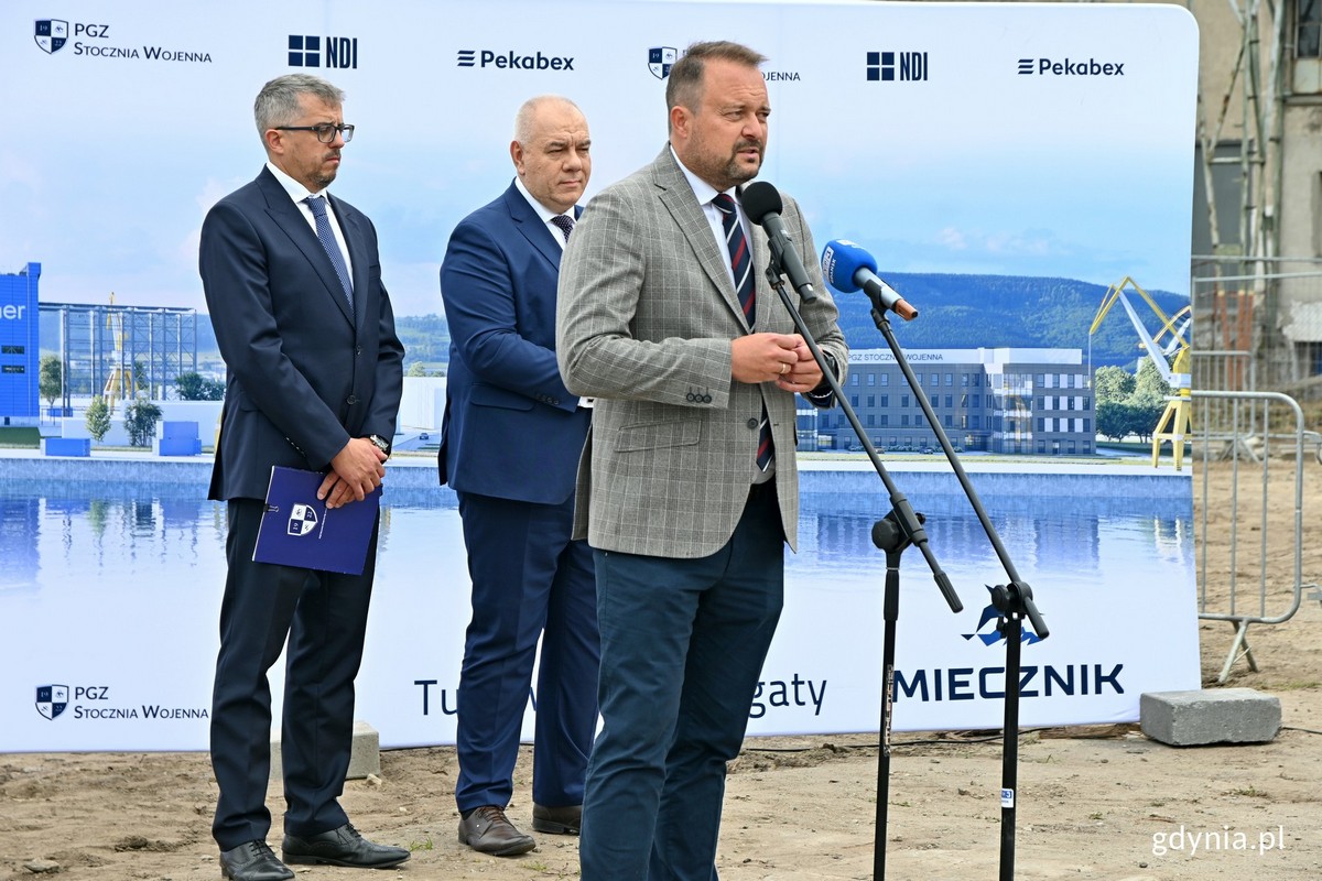 Wiceprezydent Gdyni Marek Łucyk podczas uroczystości wmurowania kapsuły czasu i kamienia węgielnego pod budowę nowoczesnych hal stoczniowych. Za nim stoją (od lewej): Paweł Lulewicz - prezes PGZ Stoczni Wojennej oraz Jacek Sasin - wicepremier i minister aktyw&oacute;w państwowych // fot. Magdalena Czernek