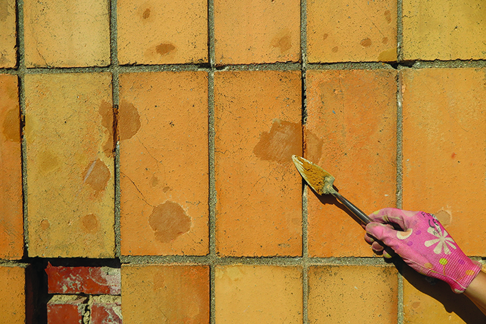 Uzupełnianie ubytk&oacute;w w płytkach na elewacji specjalnymi masami.
