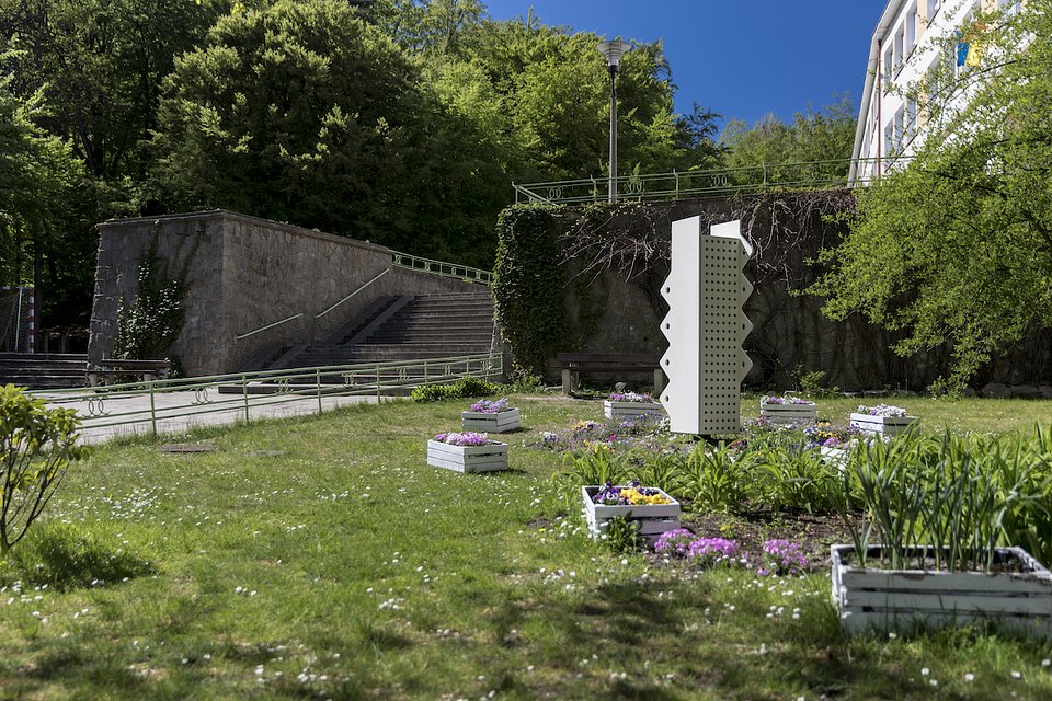 Trawnik, ogr&oacute;d, słoneczny dzień, biały hotel dla owad&oacute;w, rośliny