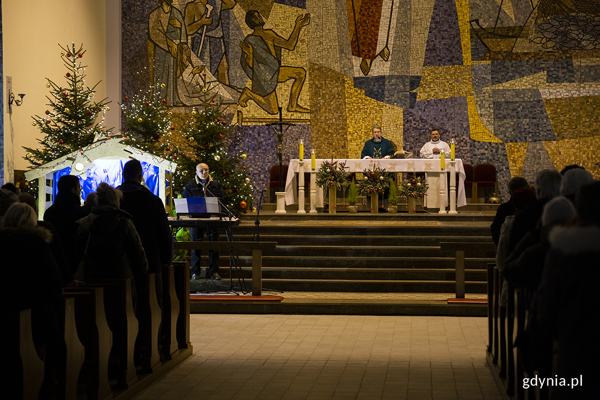 Ksiądz odprawia mszę w kościele pełnym ludzi.