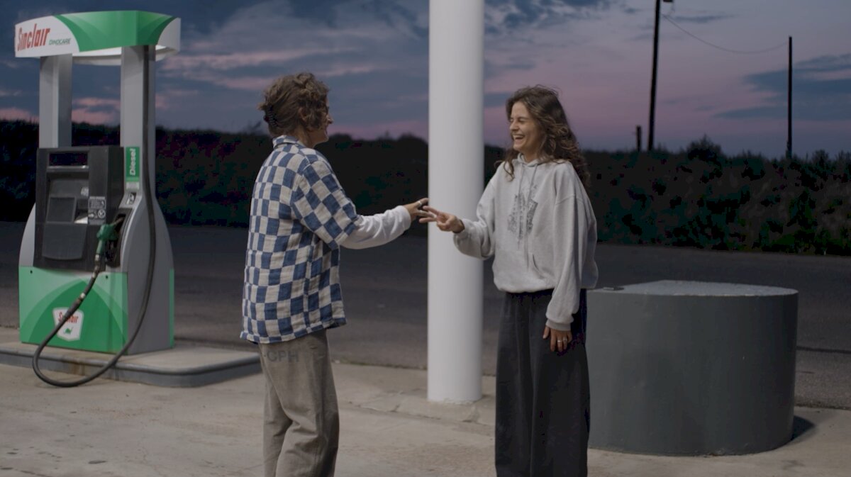 Dwie kobiety śmieją się na stacji benzynowej o zmierzchu