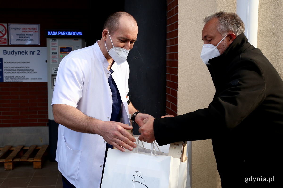 Prezydent Wojciech Szczurek (po prawej) przekazuje paczki z upominkami dla maluszk&oacute;w urodzonych 10 lutego Adamowi Ż&oacute;łtowskiemu - lekarzowi Oddziału Ginekologiczno-Położniczego Szpitala Morskiego im. PCK w Gdyni // fot. Przemysław Kozłowski