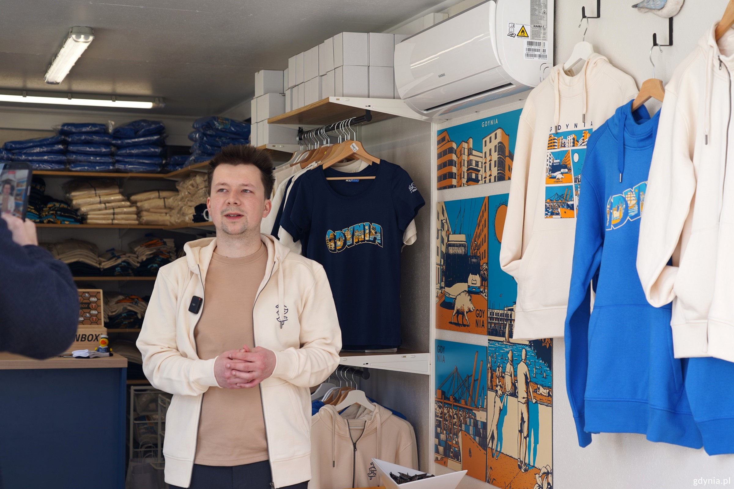 Jan Rutka w kontenerze z jubileuszowymi gadżetami gdyńskimi