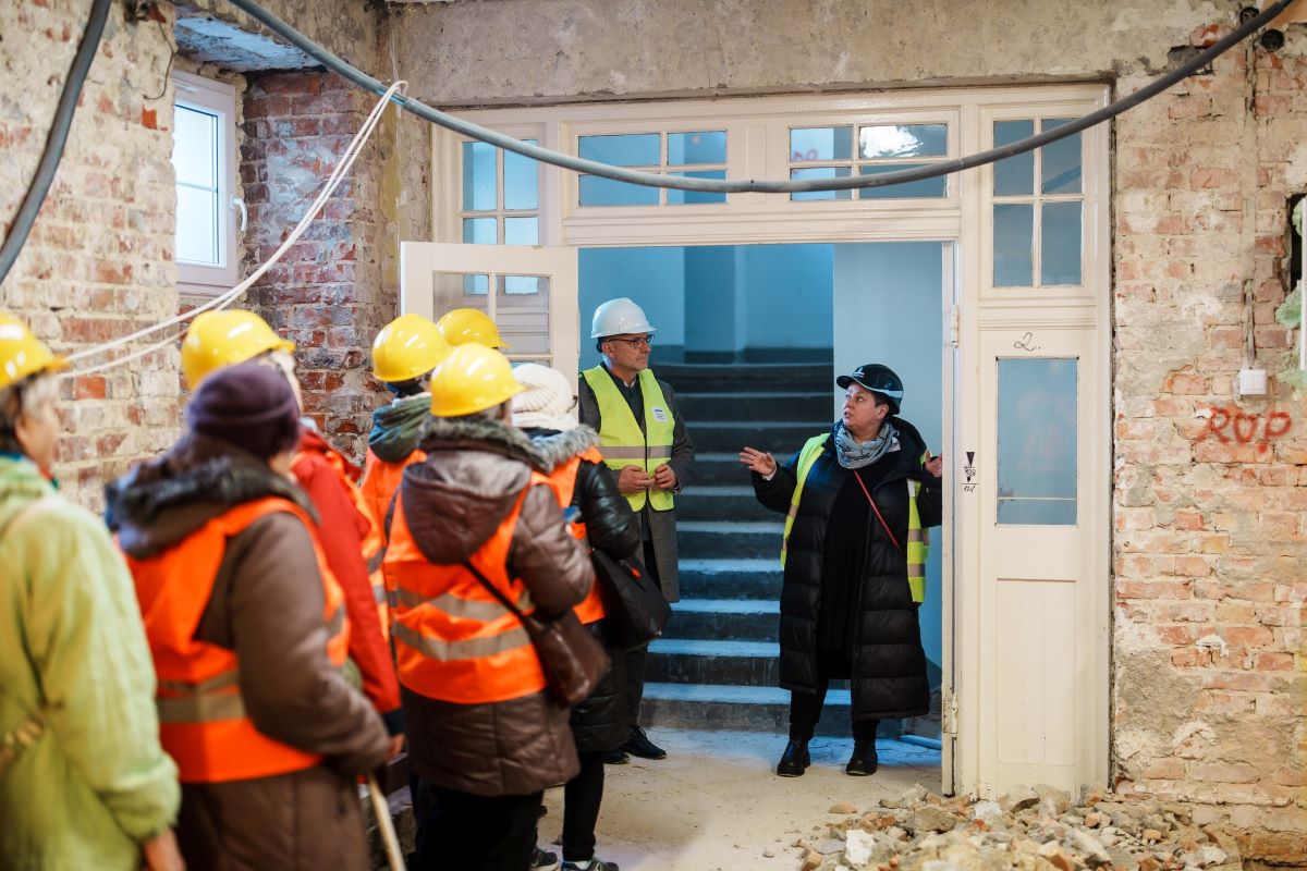 Na zdjęciu widzimy gupę senior&oacute;w i wiceprezydenta Gdyni, Michała Gucia  podczas wizyty w modernizowanym na potrzeby entrum Nowoczesnego seniora, budynku dawnego Gimnazjum nr. 1