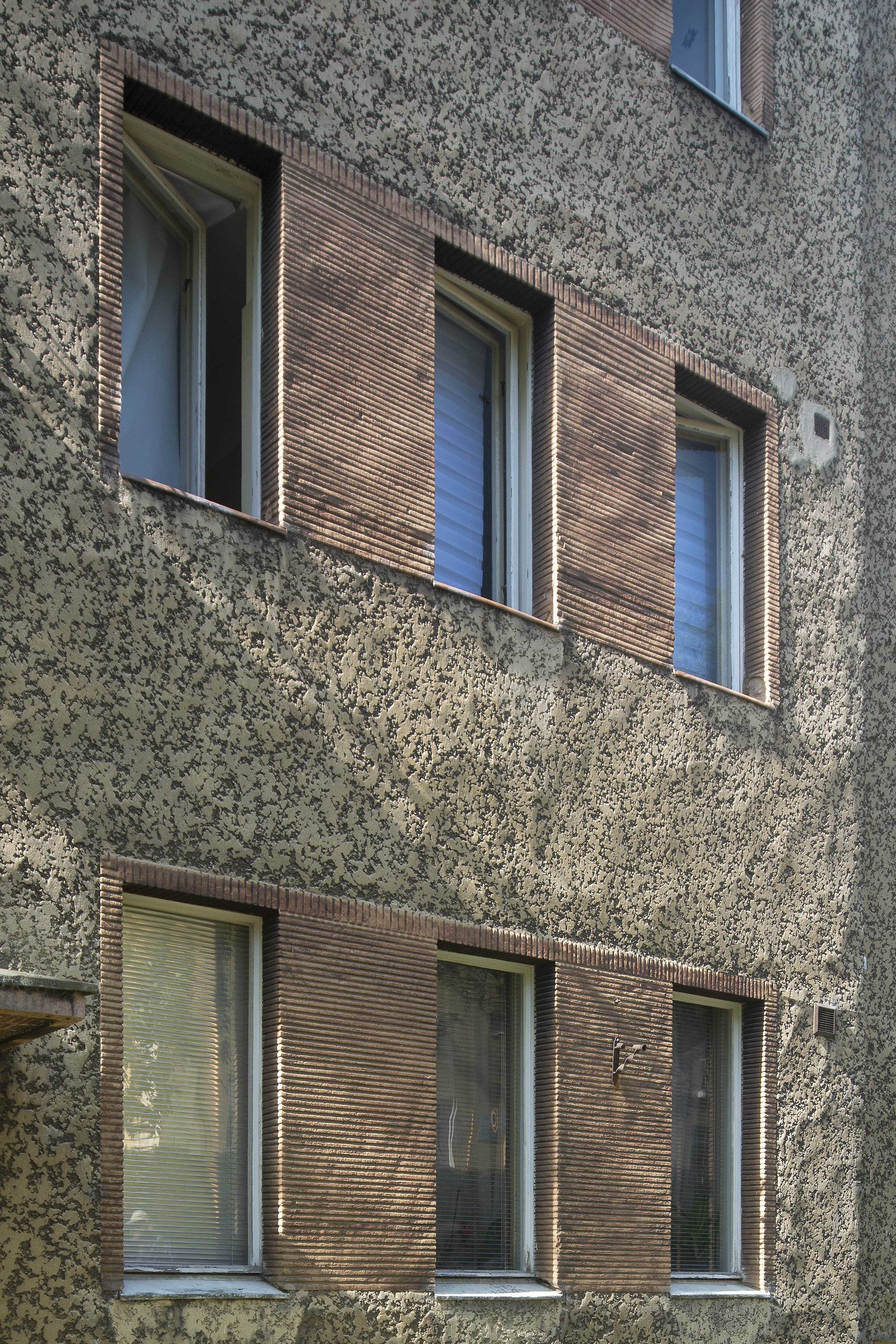 Budynek przy ul. Krasickiego z lat 30. XX w., kt&oacute;ry ma na elewacji dwa rodzaje tynk&oacute;w dekoracyjnych &ndash; szary i czerwony. W spos&oacute;b charakterystyczny w architekturze modernistycznej sąsiednie okna połączono wsp&oacute;lną dekoracją.