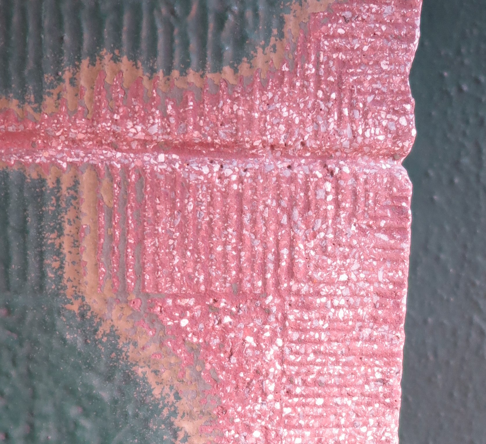 Szczeg&oacute;ł wykończenia portalu z wykutymi dłutem gęstymi rowkami.