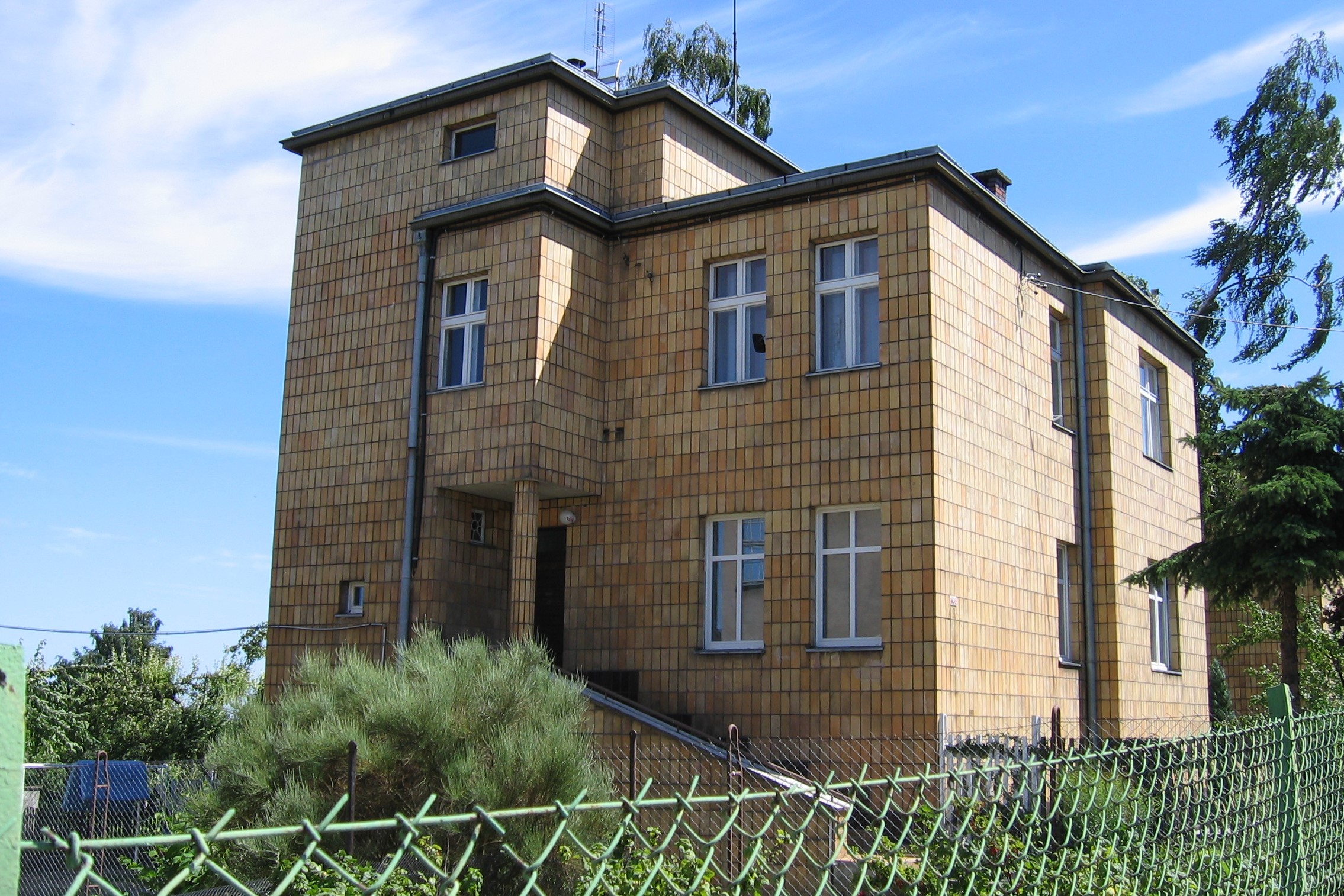 Willa w Orłowie z elewacjami oblicowanymi ż&oacute;łtymi płytkami.