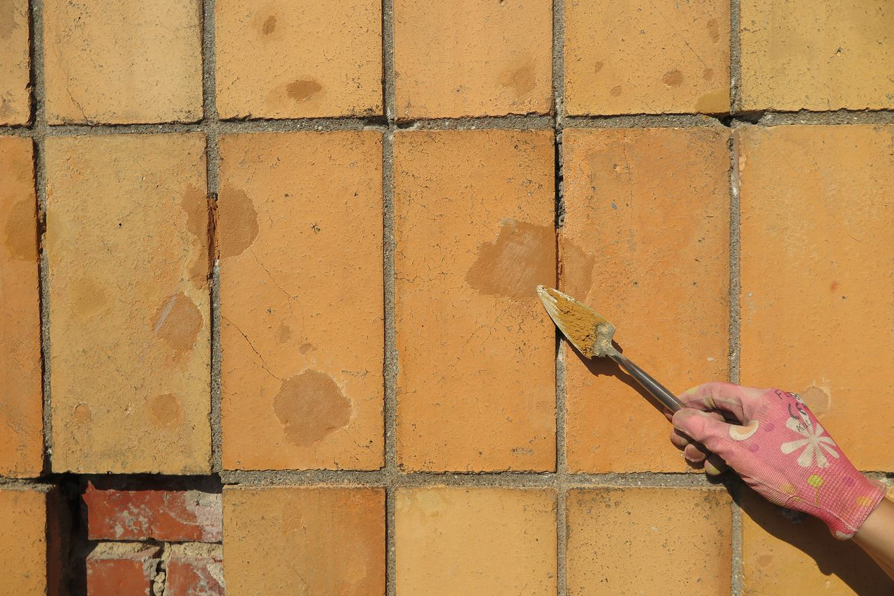 Uzupełnianie ubytk&oacute;w w płytkach na elewacji specjalnymi masami.