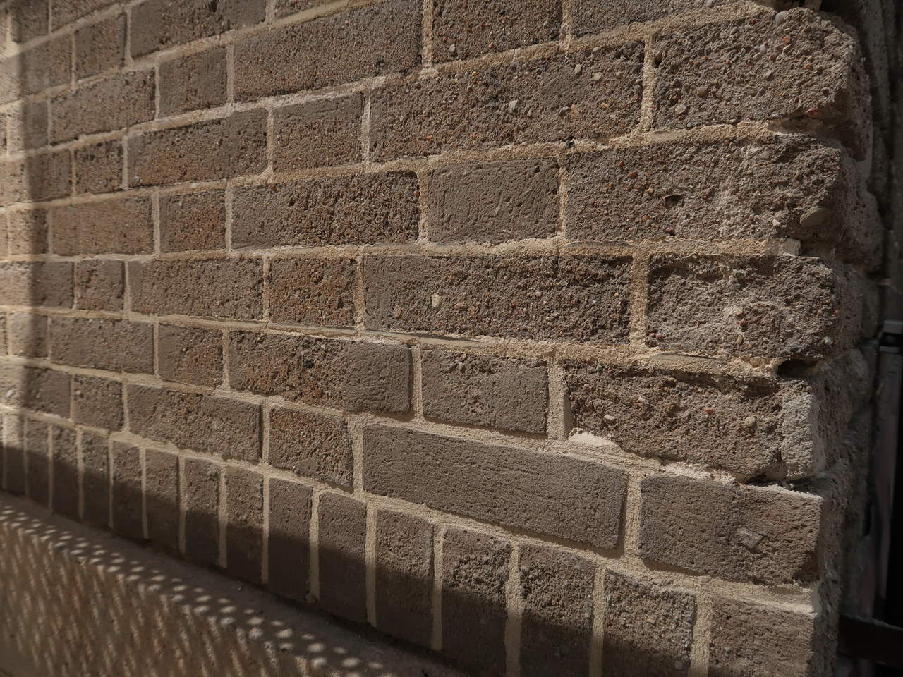 Fragment elewacji A budynku Uniwersytetu Morskiego po pracach konserwatorskich, widoczne uzupełnienia spoin oraz szarej cegły cementowej, narożnik przed remontem, fot. Biuro Miejskiego Konserwatora Zabytk&oacute;w