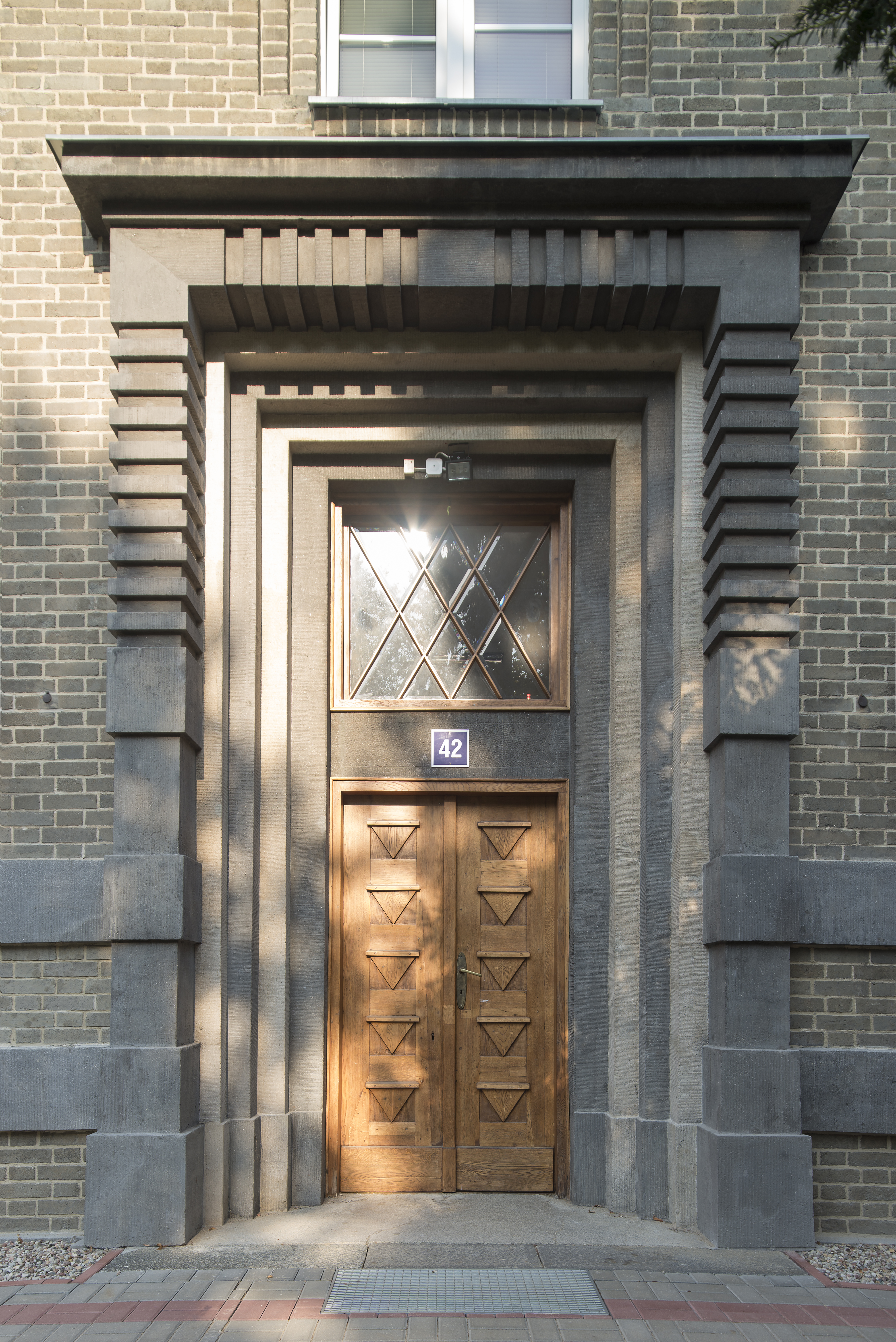 Portal budynku administracyjnego Uniwersytetu Morskiego przy ul. Morskiej 81-87 z końca lat 20. XX w., dekorowany tynkami szlachetnymi w dw&oacute;ch kolorach 