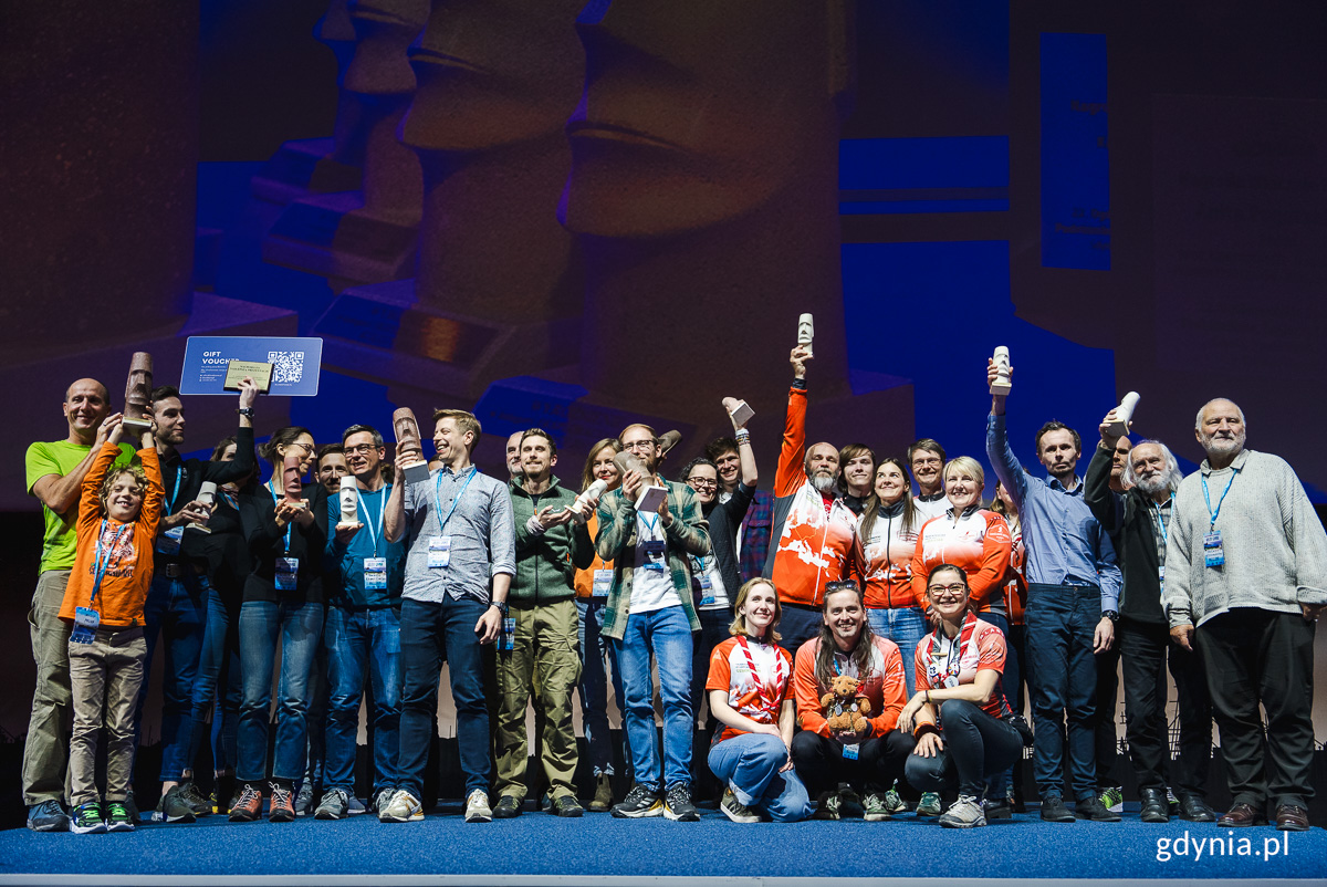 Grupa os&oacute;b z nagrodami na scenie.