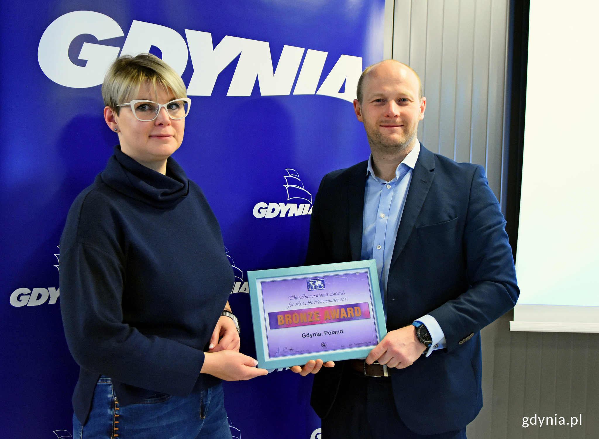 Kierownik samodzielnego referatu ds. jakości życia i integracji system&oacute;w zarządzania Małgorzata Czaja oraz wiceprezydent Gdyni ds. jakości życia - Bartosz Bartoszewicz, prezentujący wsp&oacute;lnie nagrodę zdobytą podczas LivCom Awards.  