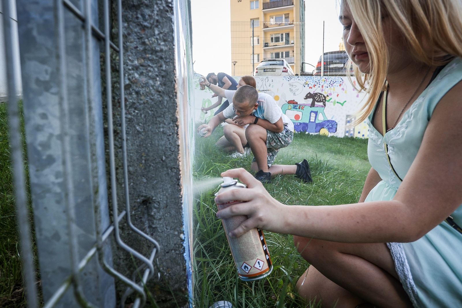 Malowanie muralu z symbolami witomińskimi z młodzieżą.