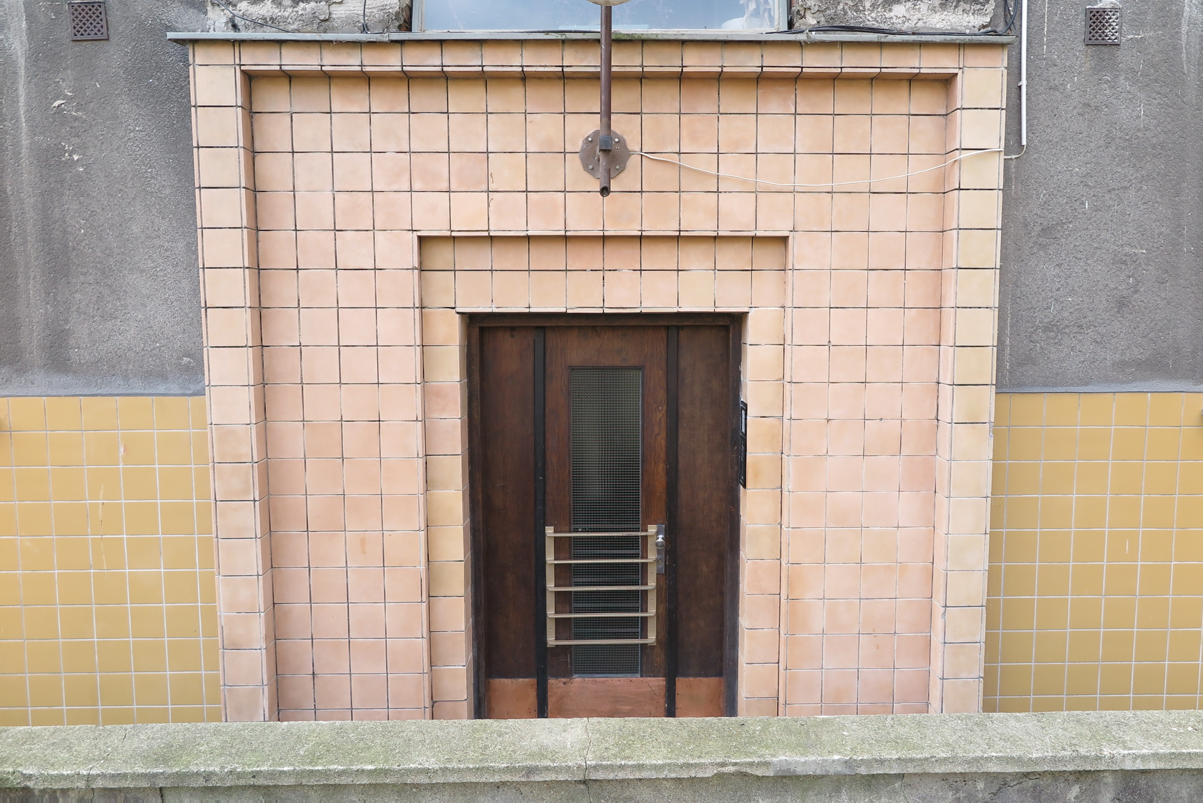Portal od podwórza budynku przy ul. 3 Maja 27-31 z lat 30. XX w., obłożony płytkami ceramicznymi.